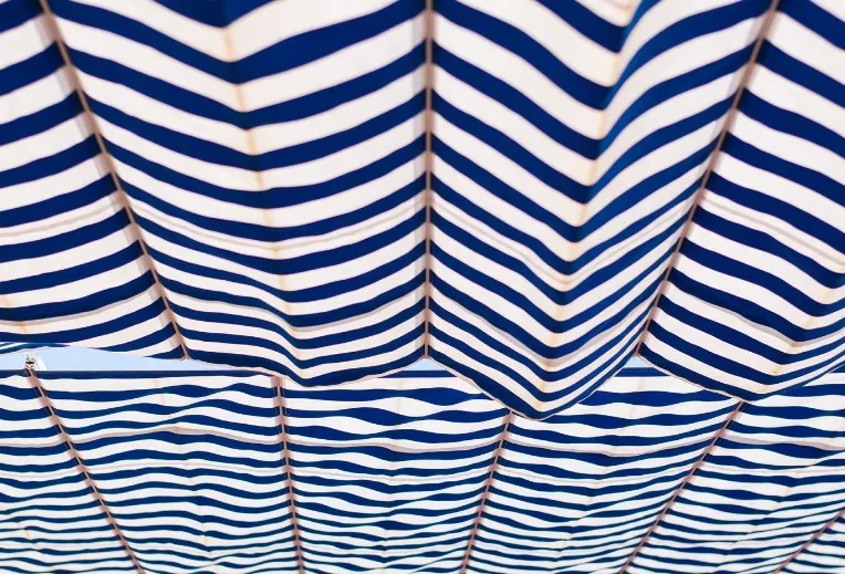 Detalle de una lona de toldo de rayas azules plegada