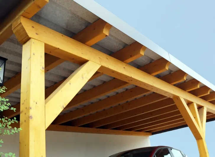 Pérgola de madera con cubierta rígida que protege una plaza de aparcamiento